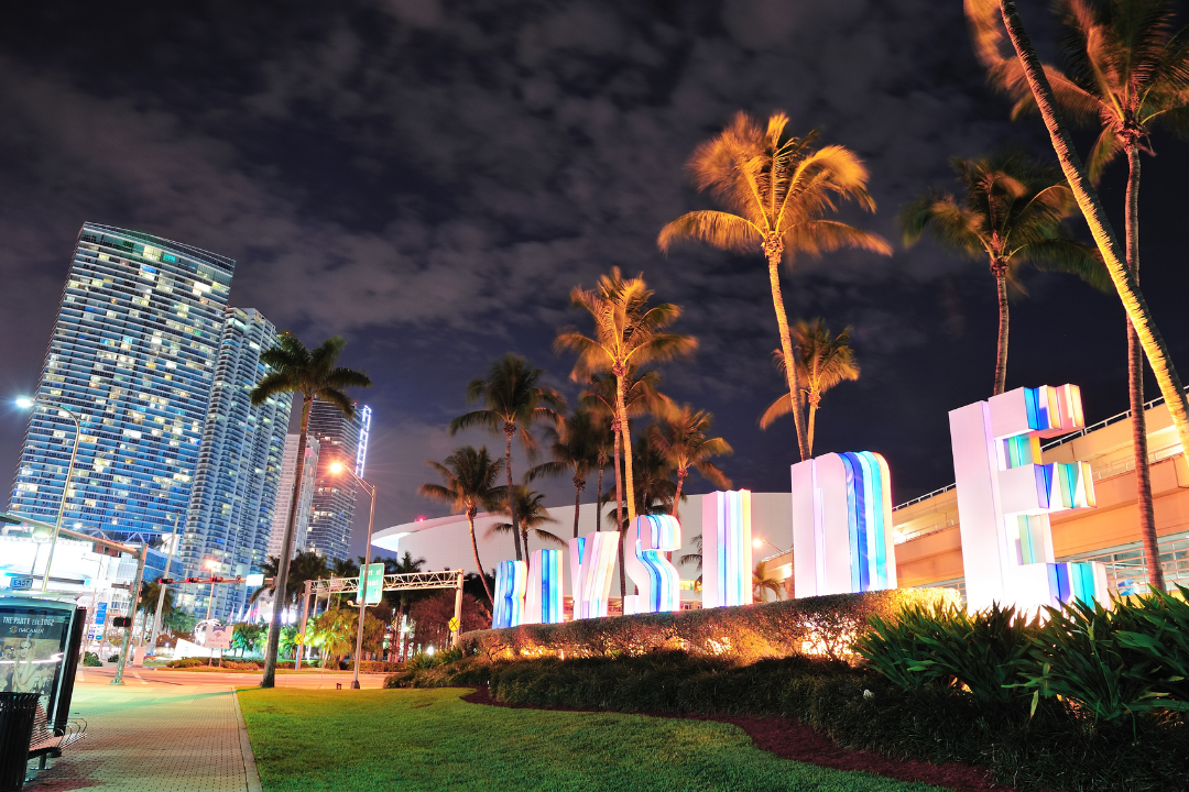 Evening view of the lit Bayside Marketplace sign in Miami, symbolizing the vibrant local economy and the potential for successful joint ventures resources.