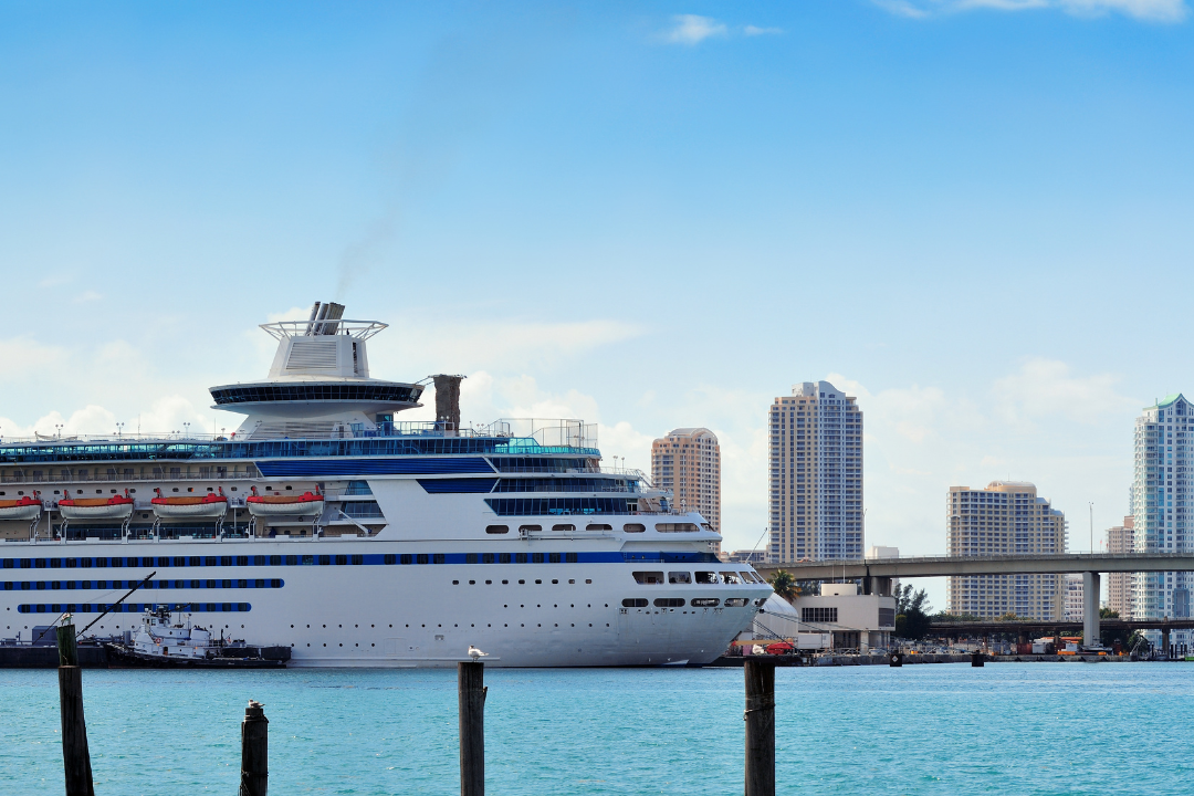 Cruise ship docked at Port of Miami with luxury high rise buildings of Brickell Key in the background, symbolizing the potential of bridge loan terms in Miami's real estate market.