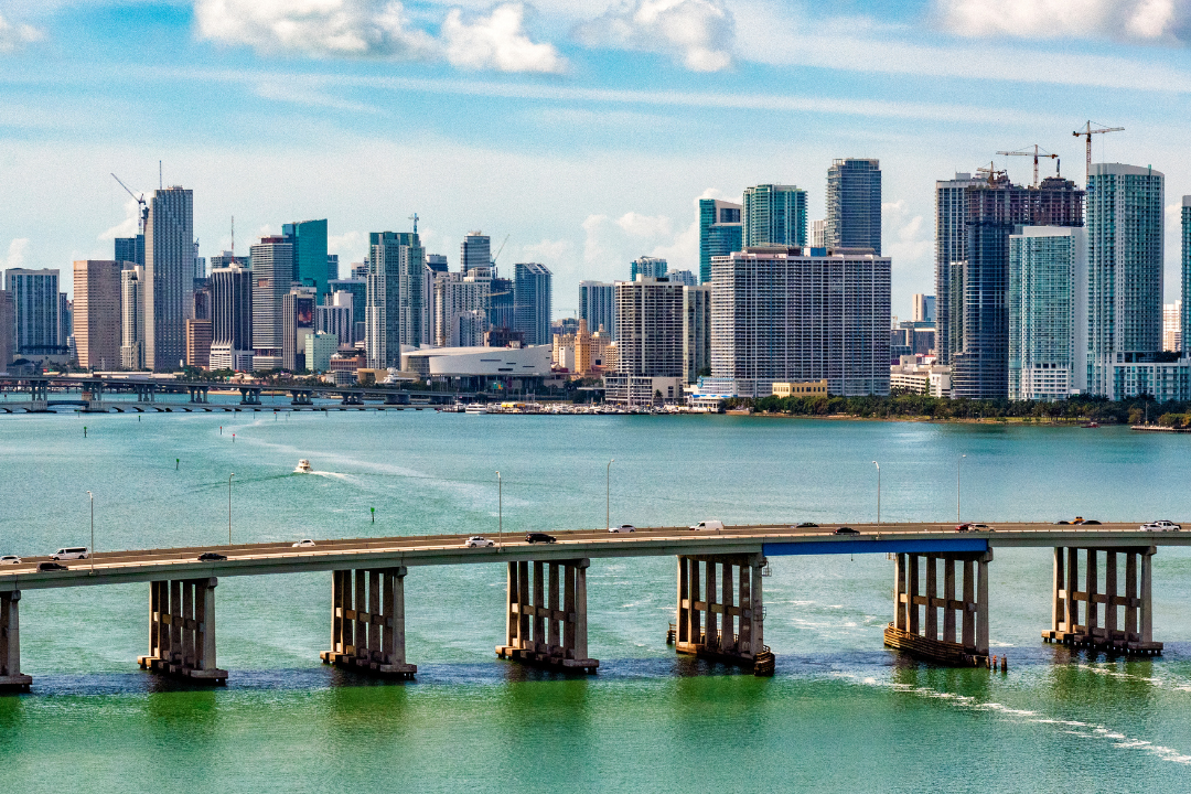 Brickell Miami skyline with Miami Heat Stadium, viewed from Rickenbacker Causeway, symbolizing the potential of Leaseback Solutions in the city's real estate market.